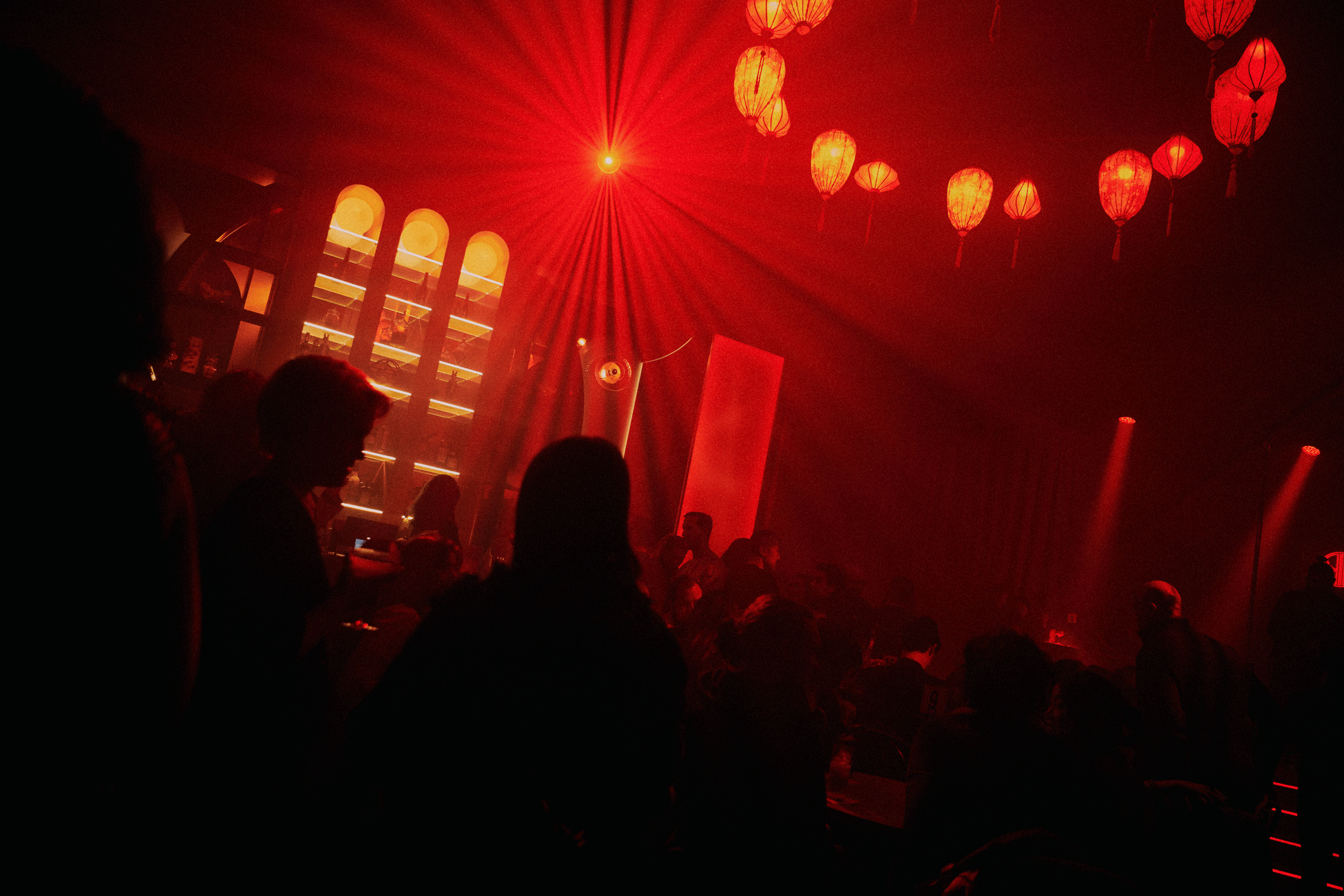 The Red Pavilion's main room glowing red beneath hanging lanterns during an event